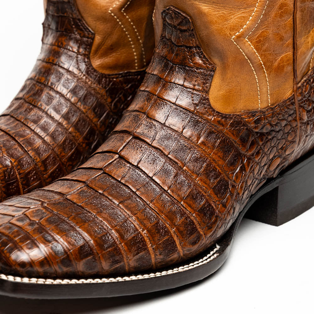 A pair of Tucson Aged Maple brown genuine leather western boots by Marco Di Milano with a textured finish; one boot upright, the other displaying the sole with "Marco Di Milano" branding.