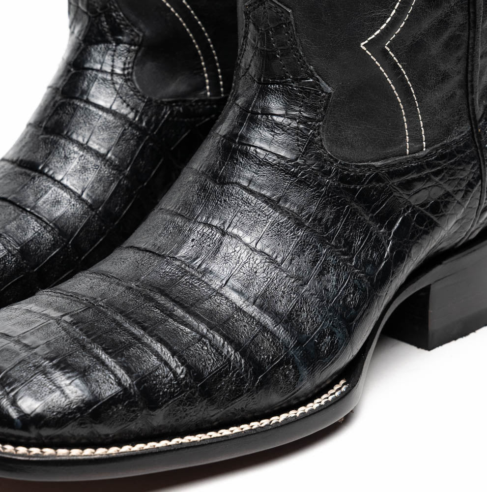 A pair of Tucson Black cowboy boots by Marco Di Milano; one boot stands upright highlighting the decorative stitching, while the other lies on its side showing the branded sole.