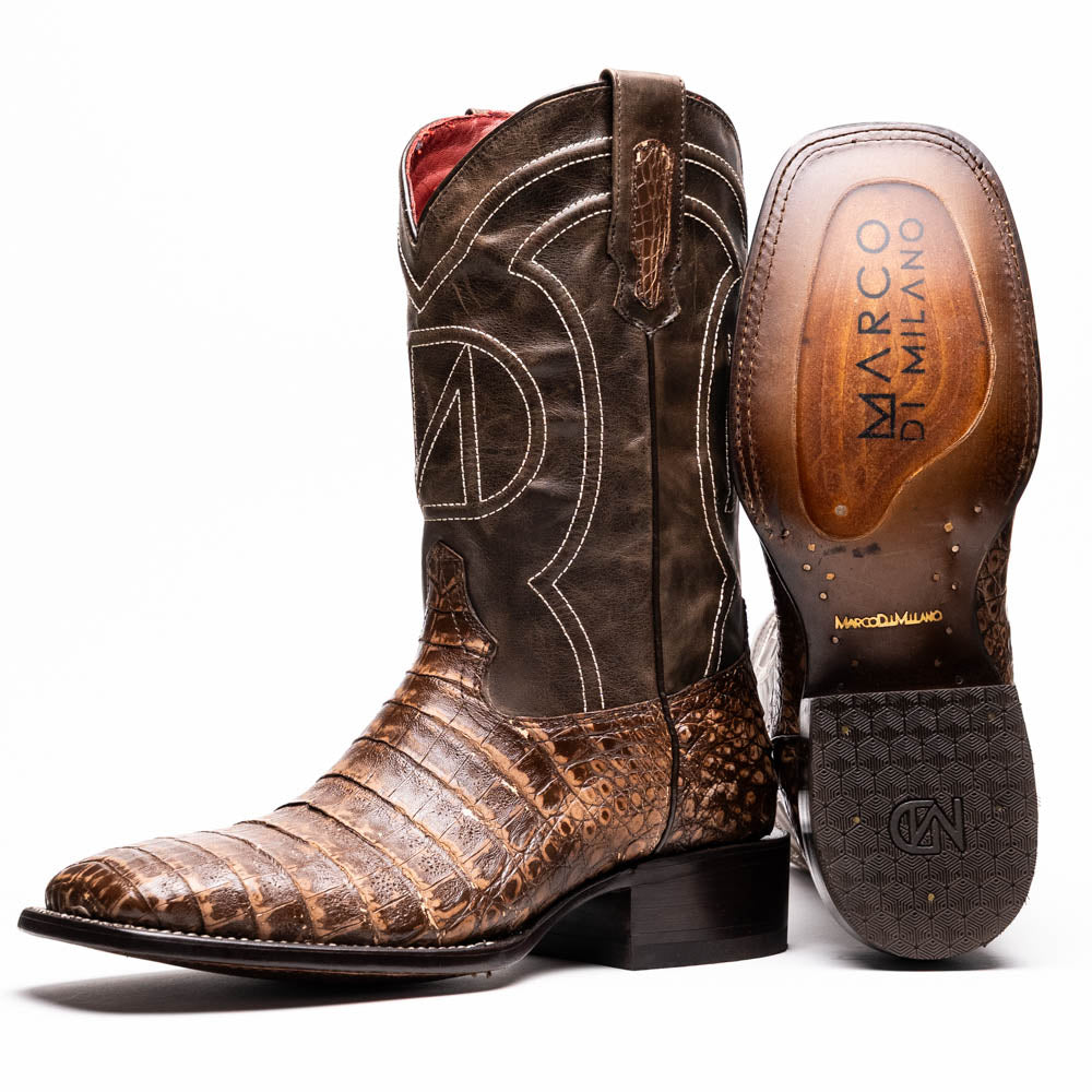 A pair of Tucson Stone Brown cowboy boots by Marco Di Milano, featuring brown leather with a reptile texture and square toe; one boot stands upright, the other displays its sole labeled with the brand.