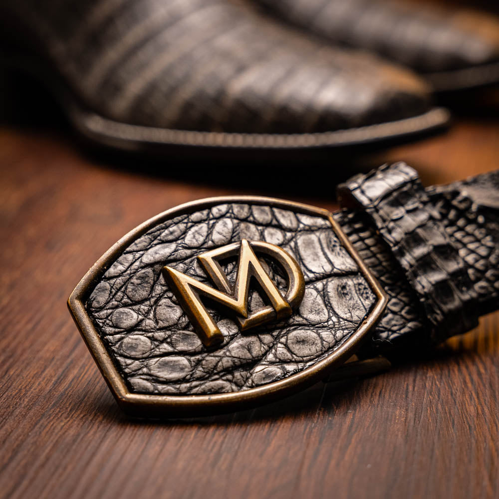 A pair of Tucson Stone Gray cowboy boots by Marco Di Milano with exotic textured leather, detailed white stitching, red inner lining, and the brand logo on the sole.