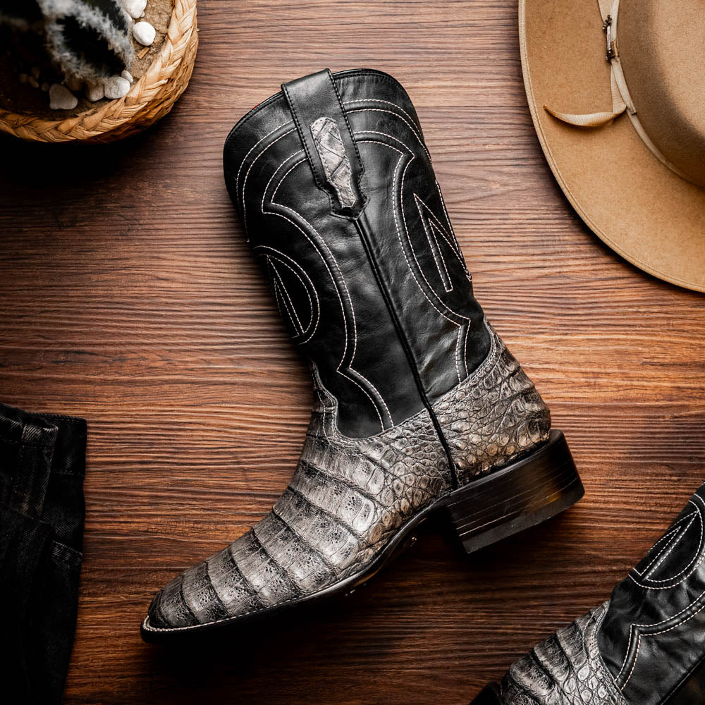 A pair of Tucson Stone Gray cowboy boots by Marco Di Milano with exotic textured leather, detailed white stitching, red inner lining, and the brand logo on the sole.