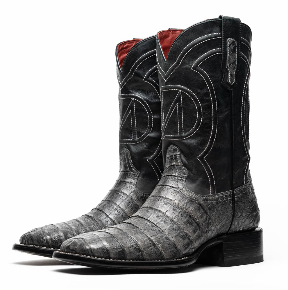 A pair of Tucson Stone Gray cowboy boots by Marco Di Milano with exotic textured leather, detailed white stitching, red inner lining, and the brand logo on the sole.