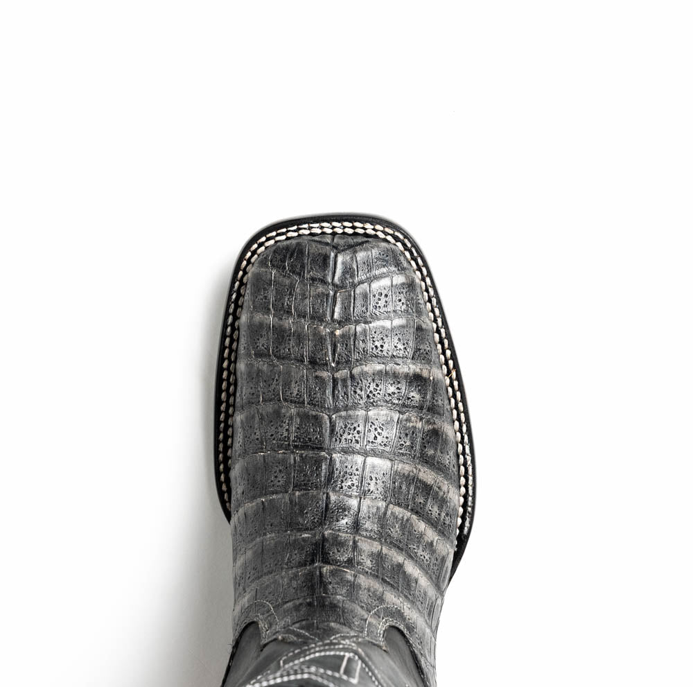 A pair of Tucson Stone Gray cowboy boots by Marco Di Milano with exotic textured leather, detailed white stitching, red inner lining, and the brand logo on the sole.