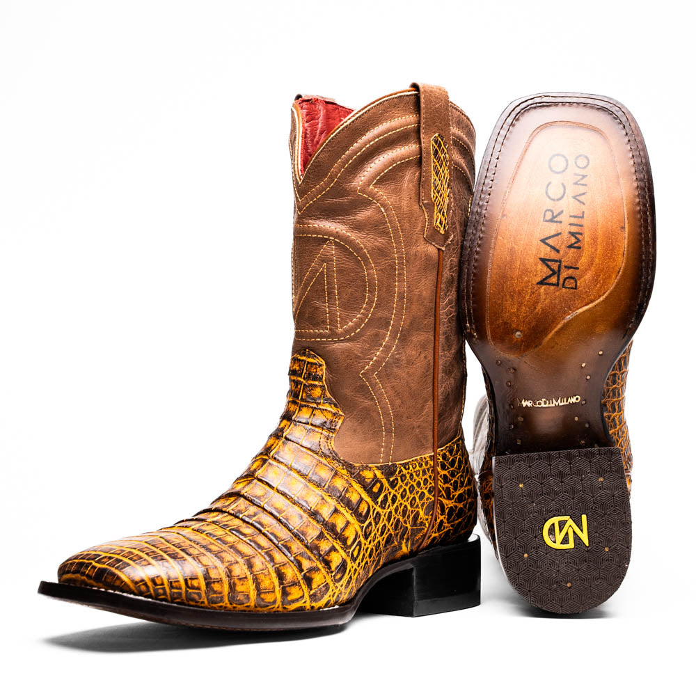The Marco Di Milano Tucson Mustard Brown men's Western boots feature brown leather uppers and yellow genuine caiman belly skin lowers; one boot stands upright, the other shows the signature square toe cowboy boot sole.