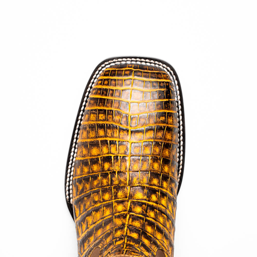 The Marco Di Milano Tucson Mustard Brown men's Western boots feature brown leather uppers and yellow genuine caiman belly skin lowers; one boot stands upright, the other shows the signature square toe cowboy boot sole.