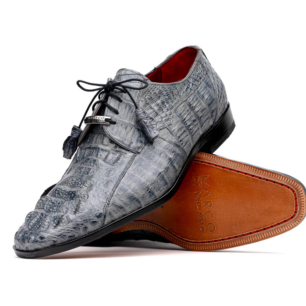 The Tulum Gray by Marco Di Milano is a luxury men’s dress shoe in genuine caiman crocodile leather, featuring black laces and a metal ornament, shown with one shoe on its side to display the branded leather sole.