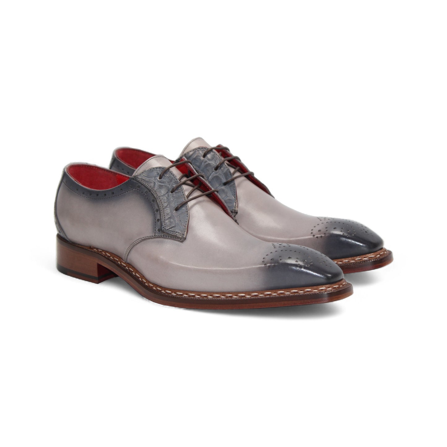 The Fennix Tyler Light Grey by Fennix of Italy is a gray and light gray dress shoe with brogue detailing, red inner lining, and a leather sole, expertly crafted in Italy and displayed in a side profile view.