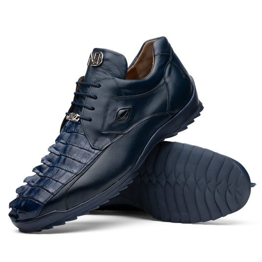 Introducing the Udine Navy by Marco Di Milano—a pair of luxury men’s sneakers crafted from exotic navy blue leather with textured uppers and durable rubber soles. One shoe stands upright while the other rests on its side, showcasing their distinctive style and impeccable craftsmanship.