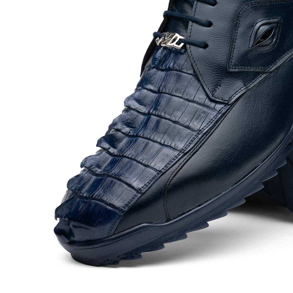 Introducing the Udine Navy by Marco Di Milano—a pair of luxury men’s sneakers crafted from exotic navy blue leather with textured uppers and durable rubber soles. One shoe stands upright while the other rests on its side, showcasing their distinctive style and impeccable craftsmanship.