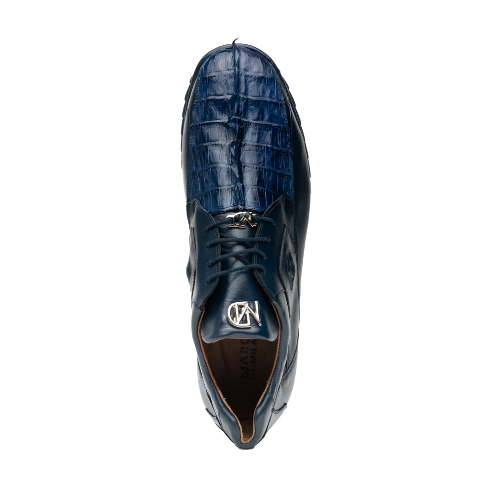 Introducing the Udine Navy by Marco Di Milano—a pair of luxury men’s sneakers crafted from exotic navy blue leather with textured uppers and durable rubber soles. One shoe stands upright while the other rests on its side, showcasing their distinctive style and impeccable craftsmanship.