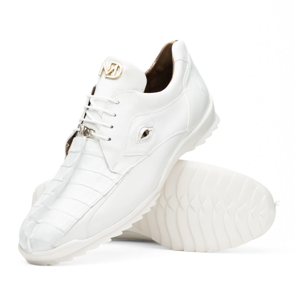 The Udine White by Marco Di Milano is a pair of luxury men’s sneakers crafted from white hornback caiman leather with a distinctive crocodile pattern, featuring a gold logo on the tongue and textured rubber soles. Displayed with one shoe upright and the other leaning against it, this footwear exudes sophistication and unique style.