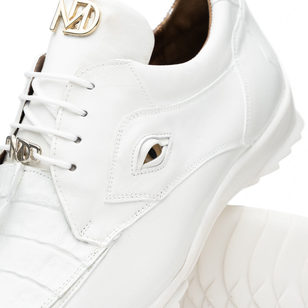 The Udine White by Marco Di Milano is a pair of luxury men’s sneakers crafted from white hornback caiman leather with a distinctive crocodile pattern, featuring a gold logo on the tongue and textured rubber soles. Displayed with one shoe upright and the other leaning against it, this footwear exudes sophistication and unique style.