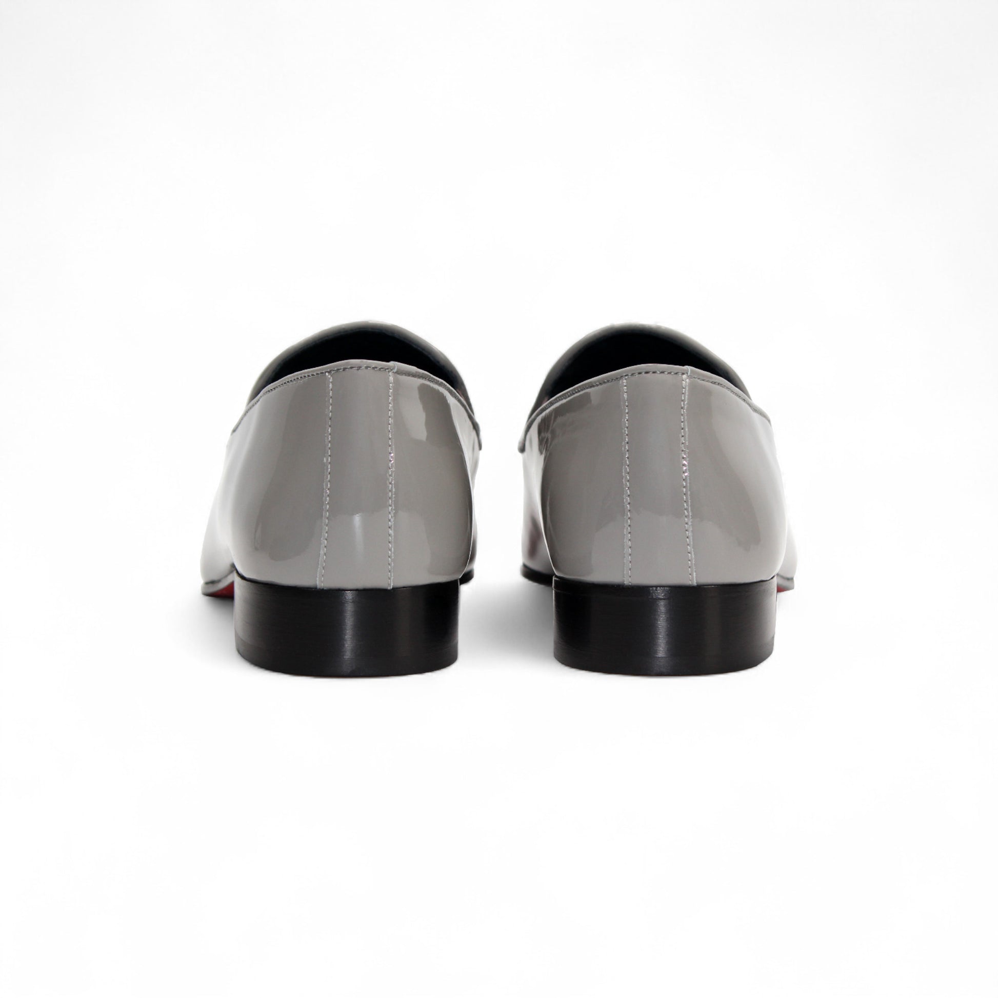 The Duca Di Matiste Duca Valenza Grey loafer features a glossy light gray finish, metal bit detail, black sole, and low heel—exemplifying Italian craftsmanship in luxury footwear. Shown in side profile on a white background.