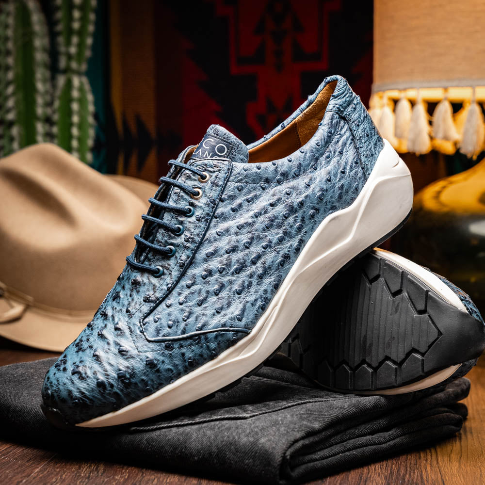 A pair of Marco Di Milano Varenna Blue Jeans sneakers—blue handcrafted leather with white soles and black laces—one upright, the other propped to display its sole.