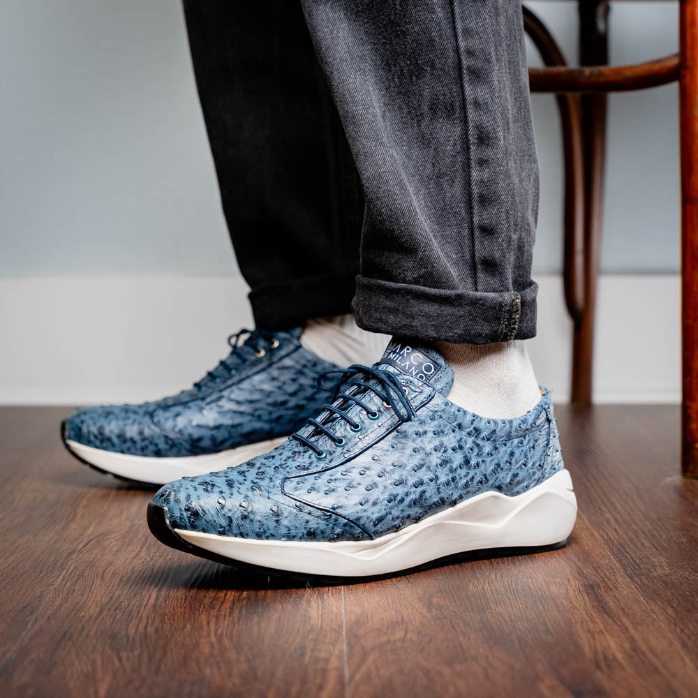 A pair of Marco Di Milano Varenna Blue Jeans sneakers—blue handcrafted leather with white soles and black laces—one upright, the other propped to display its sole.