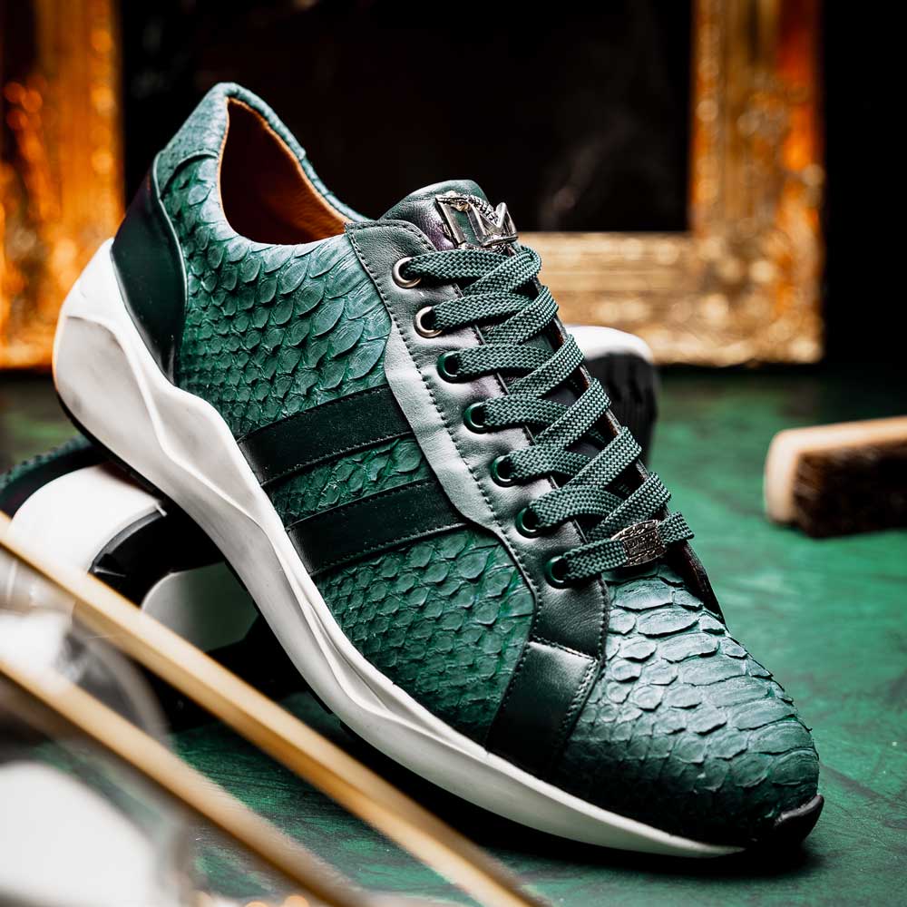 The Marco Di Milano Verona Green sneakers are luxury shoes with scale-like patterns, dark green accents, and white soles. One shoe is upright while the other lies on its side.