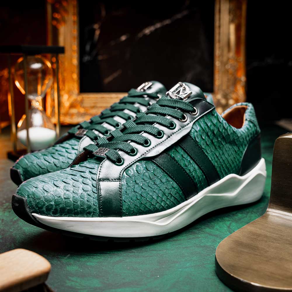 The Marco Di Milano Verona Green sneakers are luxury shoes with scale-like patterns, dark green accents, and white soles. One shoe is upright while the other lies on its side.