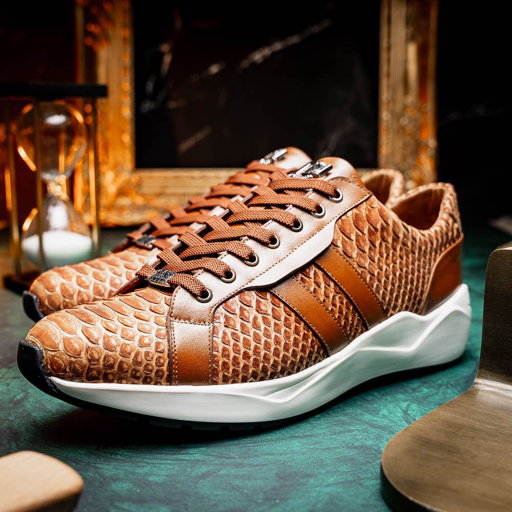 The Marco Di Milano Verona Honey is a brown luxury sneaker with a textured, reptile-like pattern, leather accents, brown laces, and a white sole. One men’s genuine calfskin shoe stands upright; the other displays its sole.