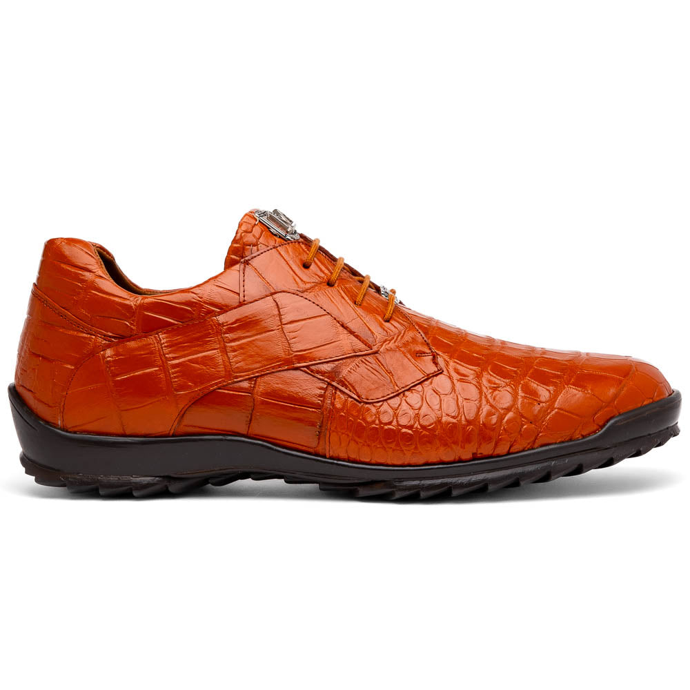 The Marco Di Milano Vulcan Honey features orange, crocodile-patterned leather dress shoes with hand-painted finishes and black rubber soles; one shoe stands upright while the other rests on its side below.