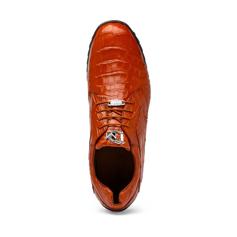 The Marco Di Milano Vulcan Honey features orange, crocodile-patterned leather dress shoes with hand-painted finishes and black rubber soles; one shoe stands upright while the other rests on its side below.