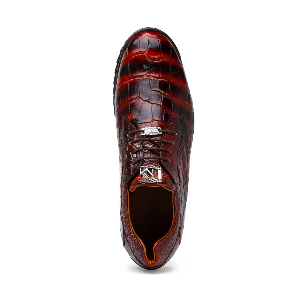 The Vulcan Rustic Cognac by Marco Di Milano features brown crocodile-pattern leather dress shoes with black rubber soles, one shoe upright and the other tilted—showcasing luxury footwear with exquisite hand-painted finishes.
