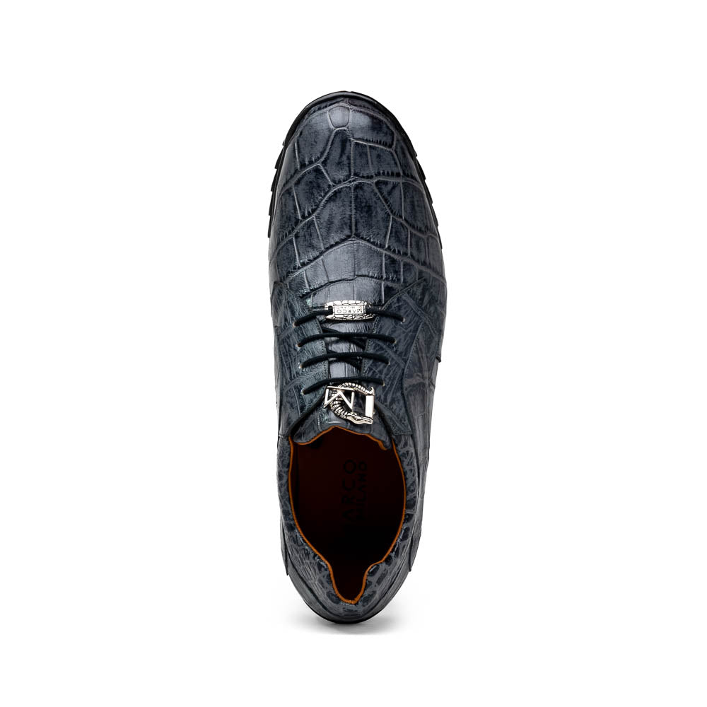 A pair of Marco Di Milano Vulcan Rustic Gray men's dress shoes, showcasing luxury footwear with crocodile-patterned leather, hand-painted finishes, and metal lace accents—one upright, one on its side to display the sole.