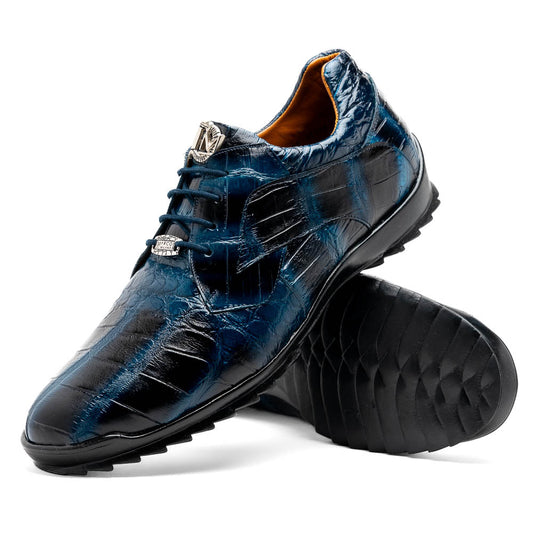 The Vulcan Rustic Navy by Marco Di Milano features glossy blue and black lace-up dress shoes with textured leather, rubber soles, and exquisite hand-painted finishes—one upright, the other propped beneath it—showcasing luxury footwear.