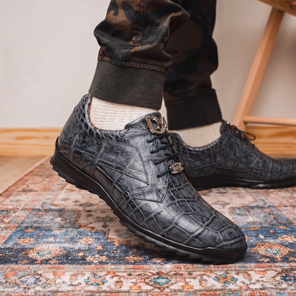 A pair of Marco Di Milano Vulcan Rustic Gray men's dress shoes, showcasing luxury footwear with crocodile-patterned leather, hand-painted finishes, and metal lace accents—one upright, one on its side to display the sole.