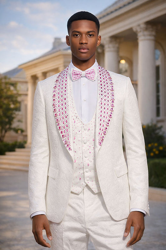 A man wears the Manzini ZARA 3-Piece Slim-Fit Men's Rhinestone Floral Pattern Tuxedo Suit in White/Pink, standing before a classical building and highlighting the elegance of Manzini’s formalwear.