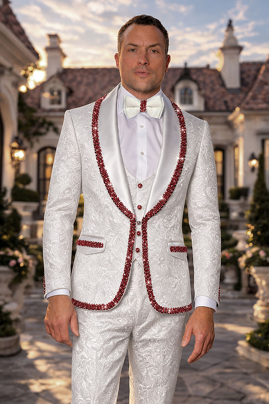 A man wears the Manzini SOFIA 3-Piece Men's Shiny Rhinestone Trim Floral Textured Tuxedo Suit in White/Red, featuring a satin shawl lapel and white bow tie, standing outdoors with a mansion in the background.