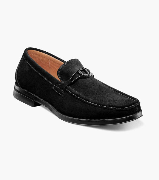Introducing the Stacy Adams - PALLADIAN Moc Toe Slip On in black suede, featuring a moc toe and metal buckle detail. This stylish shoe includes a cushioned insole, low heel, and visible stitching all presented on a sleek white background.