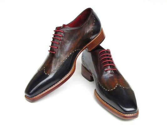 The Paul Parkman Wingtip Oxford Goodyear Welted Navy Red Black - 081-MIX features polished, handmade craftsmanship with a unique blend of navy, red, and black hues, complemented by red laces and decorative perforations. This classic wingtip oxford by Paul Parkman exudes timeless elegance.