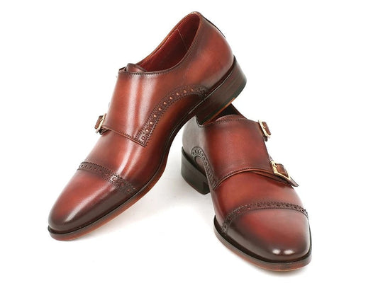 A pair of Paul Parkman Captoe Double Monkstrap shoes in camel and light brown leather, showcasing decorative perforations and exceptional craftsmanship.