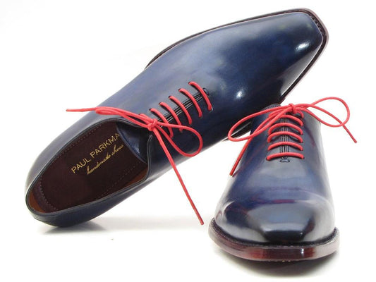 A pair of the Paul Parkman Goodyear Welted Wholecut Oxfords in navy blue, hand-painted for a sleek finish. These exquisite dress shoes feature red laces, a pointed toe, and the signature Paul Parkman branding on the inside. Their construction highlights a classic Goodyear welt for superior durability and style.