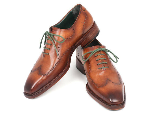 Introducing the Paul Parkman Wingtip Oxford, model 87CML66, a pair of camel brown dress shoes crafted with a Goodyear welted sole, featuring brogue detailing and distinguished green laces.