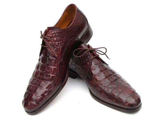 A pair of Paul Parkman Brown & Bordeaux Crocodile Embossed Calfskin Derby Shoes, model 1438BRD, showcasing hand-painted details in rich brown leather with a crocodile pattern, complete with laces and an antique burnished leather sole, elegantly arranged with one shoe resting atop the other.