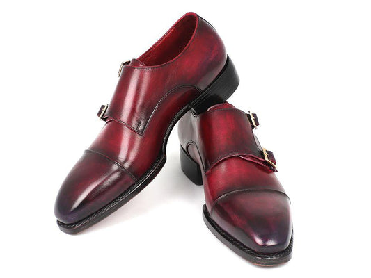 A meticulously hand-finished pair of Paul Parkman Triple Leather Sole Hand-Welted Cap Toe Monkstraps in a polished dark red, featuring black soles, elegantly displayed on a white background.