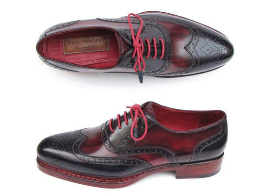 These Paul Parkman Triple Leather Sole Wingtip Brogues in Navy & Red - 027-TRP-NVYBRD feature striking red laces and detailed brogue accents. Made from hand-painted deep burgundy and black leather, these shoes have Goodyear welted wooden soles for enhanced durability and style.