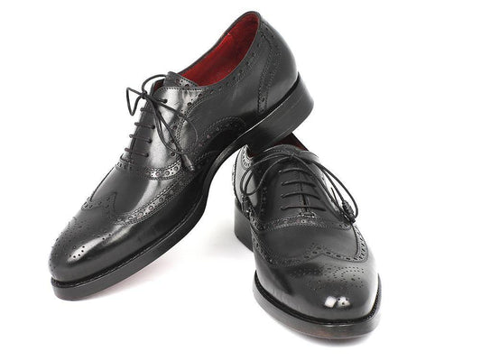 The Paul Parkman Wingtip Oxford Goodyear Welted Black - 027-BLK, a pair of men's handmade black leather dress shoes featuring decorative perforations and laces, crafted by the renowned brand Paul Parkman using Goodyear welted construction. The shoes are showcased against a white background.