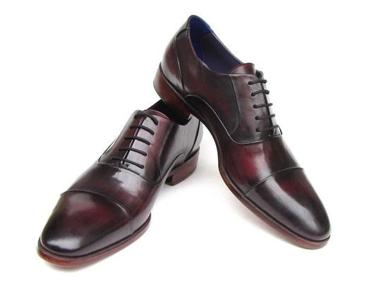 A pair of elegant, hand-painted black and purple leather Oxford shoes with cap toes, featuring laces and a slight heel by Paul Parkman are displayed.