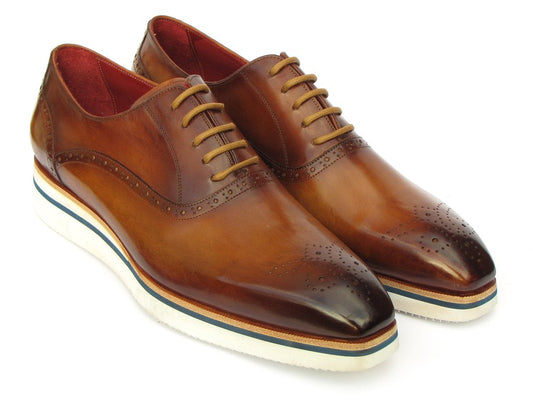 The Paul Parkman Smart Casual Brown Oxfords - 184SNK-BRW are brown leather dress shoes with brogue detailing and white soles, accentuated by a navy stripe. These stylish shoes from Paul Parkman feature a leather lining for added comfort.