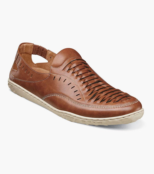 The Stacy Adams Ibiza Woven Vamp Moc Toe Slip On in Sienna features a woven cutout design, cushioned footbed, beige rubber sole, closed toe, and elastic heel strap.