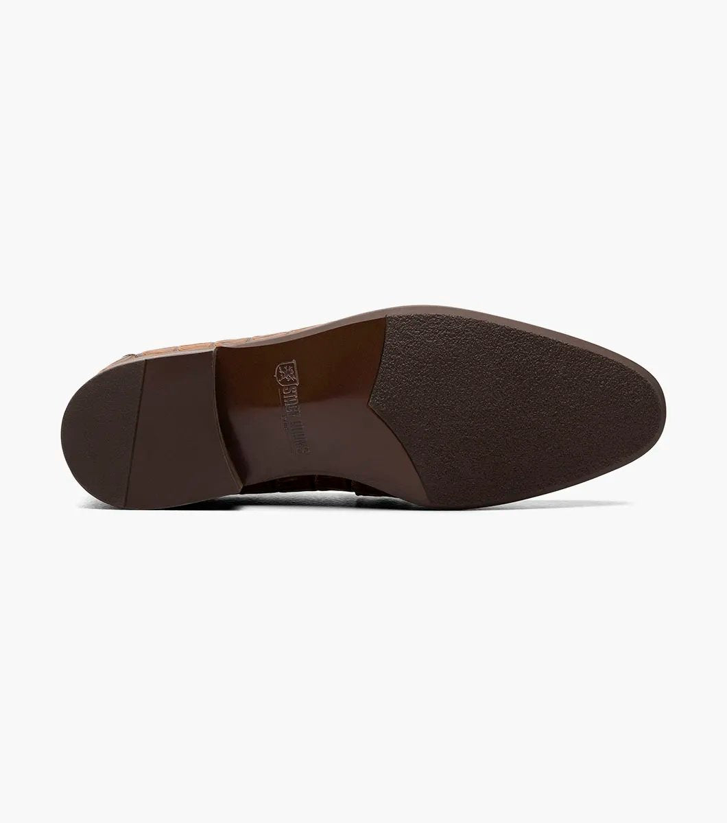 The STACY ADAMS Ferdinand Moc Toe Bit Slip On in Cognac features croco print leather, a decorative metal bit, and a cushioned memory foam footbed, displayed on a white background.