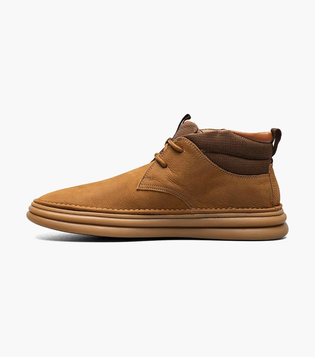 The Stacy Adams DELSON Plain Toe Chukka Boot in Camel (model 25556-228) has a durable rubber sole and lace-up front, offering anatomical arch support for all-day comfort against the crisp white background.