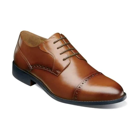 The Stacy Adams Barnett Cap Toe Oxford in Scotch is a brown burnished leather lace-up shoe with decorative perforations, a Memory Foam footbed for comfort, and a low black heel.