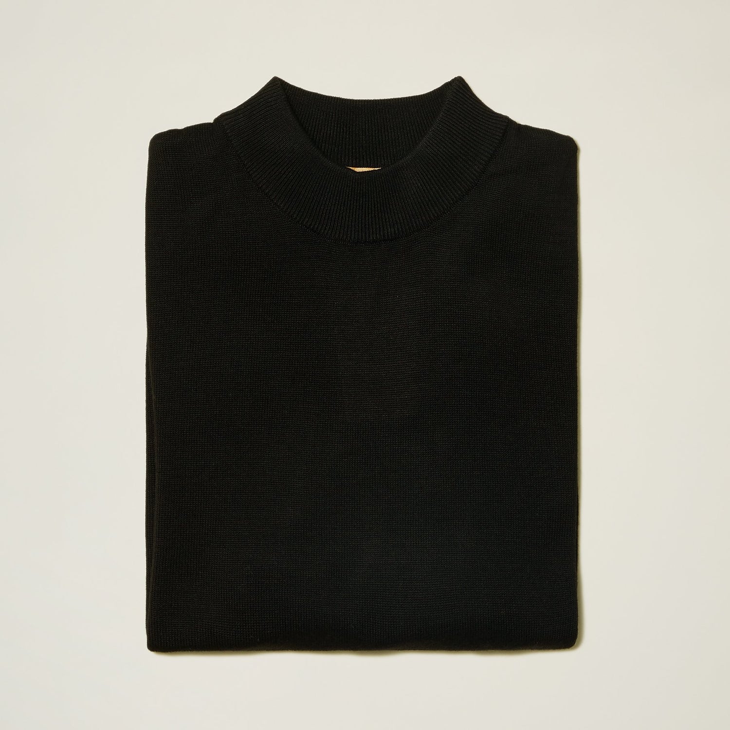 A neatly folded Inserch Cotton Blend Mock Neck Sweater Black 4308-00001, crafted from a comfortable cotton blend, rests on a plain white background.