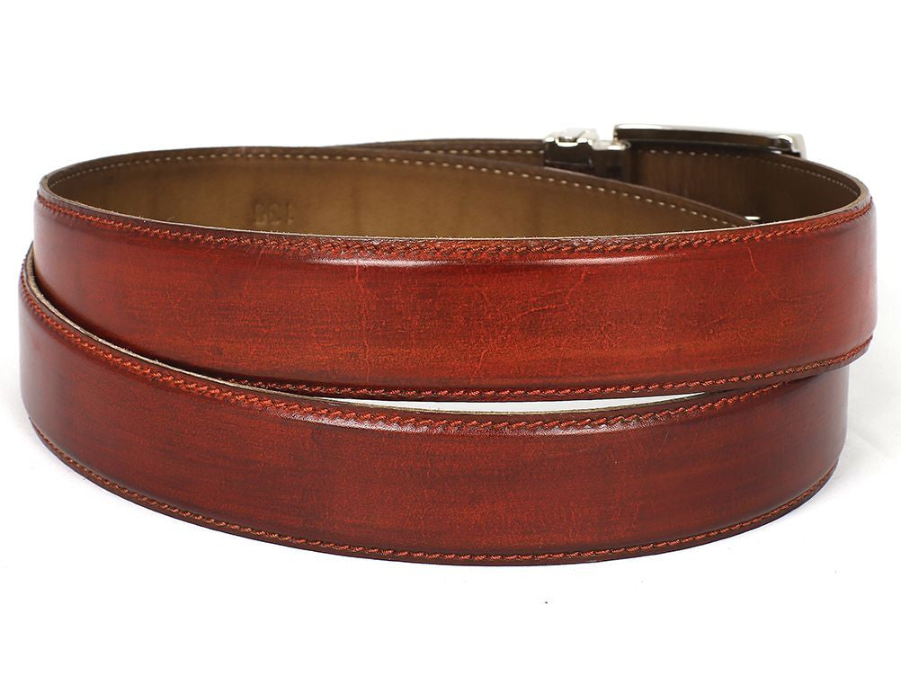 A customized Paul Parkman leather belt, hand-painted in a reddish-brown hue from Italian calfskin, featuring a silver buckle with an engraved logo and visible stitching, displayed coiled.