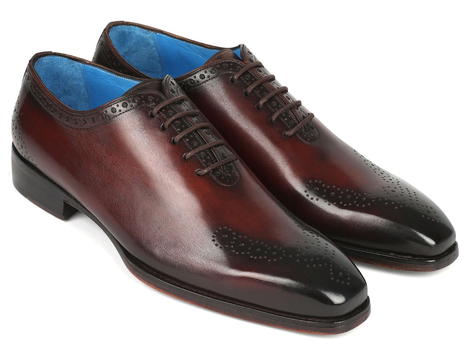 A pair of Paul Parkman Goodyear Welted Punched Oxfords in brown, crafted from intricately hand-painted calfskin featuring decorative perforations, lace-up closures, and a vibrant blue lining.