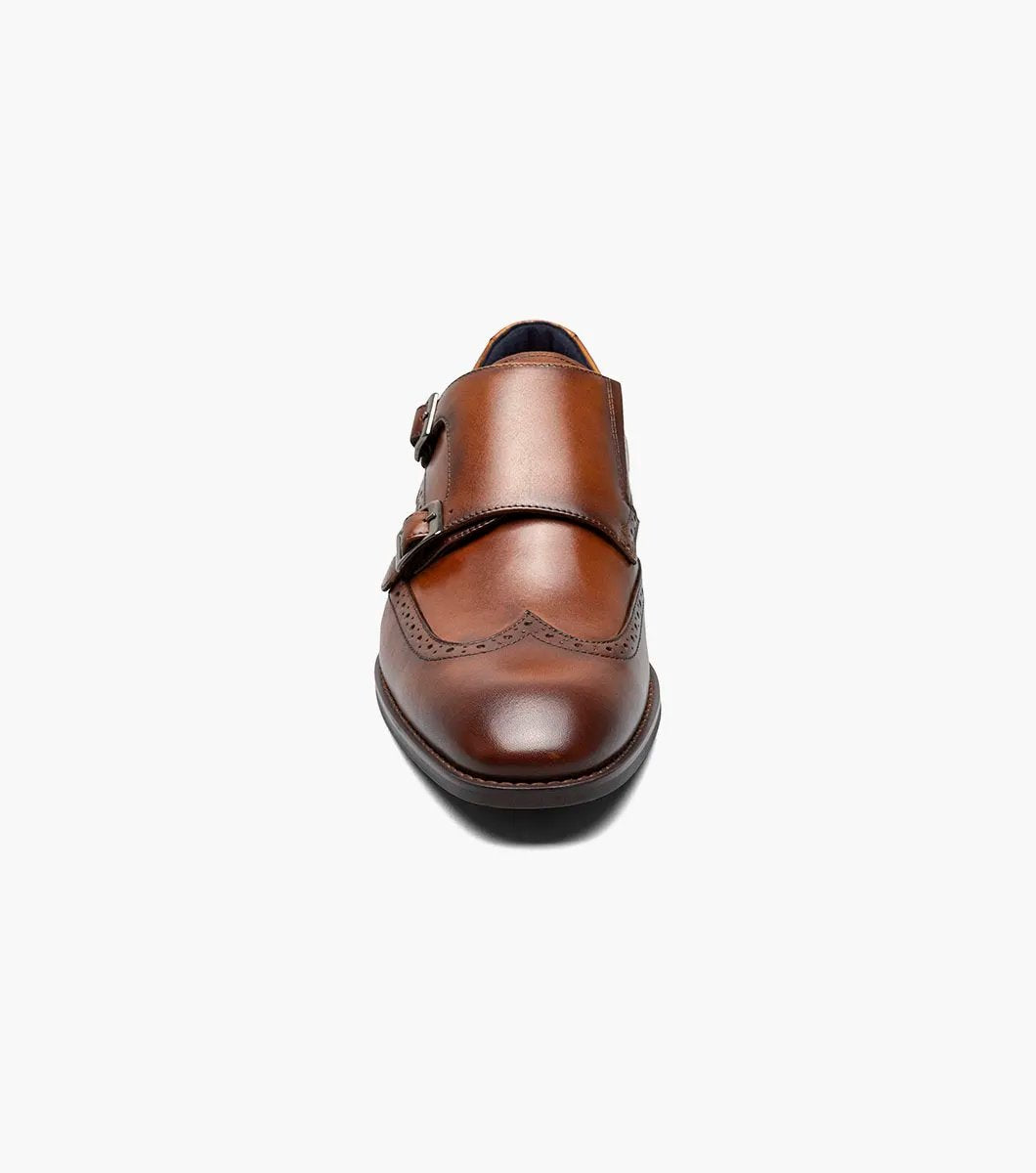 The STACY ADAMS Karson Wingtip Double Monk Strap dress shoe in Cognac features decorative perforations and a low heel, shown on a white background. Model: 25570-221.