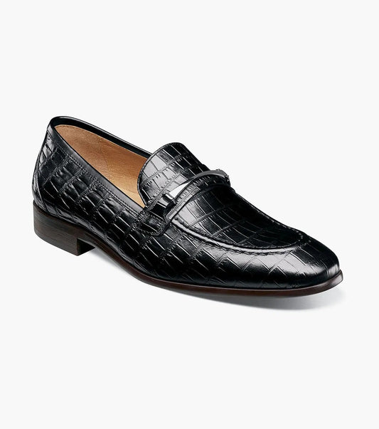 The Stacy Adams FERDINAND Moc Toe Bit Slip On in black (25455-001) features a black croco print leather upper, a low heel, and a stylish bit detail across the top. Designed for both elegance and comfort, this STACY ADAMS slip on offers a Memory Foam footbed for all-day wear, showcased against a white background.